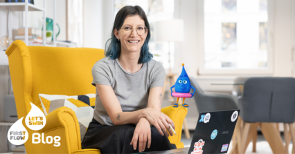 Mama sitzt auf einem Sessel im Wohnzimmer – Erfahrungsbericht über First Flow Babyschwimmen mit ihrem Baby.